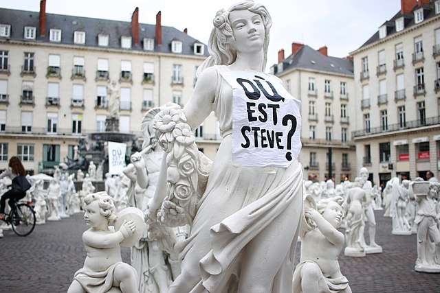 The sculpture of a woman wears a white fabric cover on which it says printed: Where is Steve?