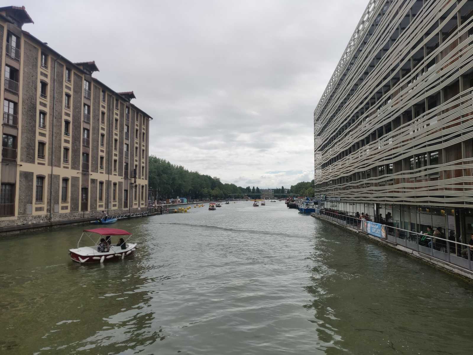 Blick auf den Canal de l'Ourcq in Paris, Urbanismus, grünes Wasser, Touristenboote auf dem Gewässer, Stadt und Mensch, bateau de plaisance, hostel ourcq, metropole, reisende der städte, städtereisen,